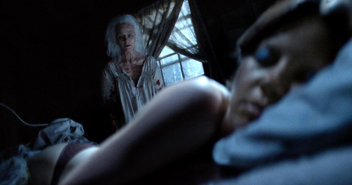 An elderly woman watches a sleeping guest.