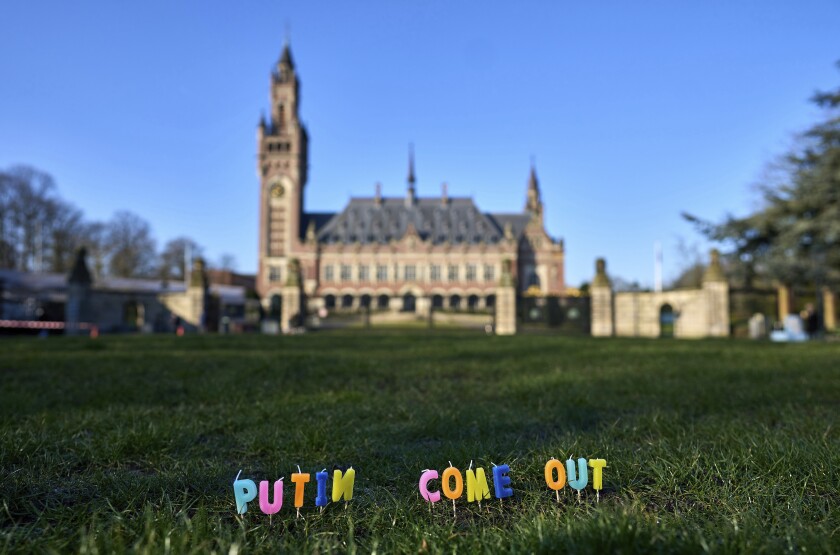 Candles are set in the grass with the text 'Putin Come Out' in front of the International Criminal Court in The Hague, Netherlands, Monday, March 7, 2022. A representative for Kyiv has urged the United Nations' top court to order Russia to halt its devastating invasion of Ukraine, at a hearing snubbed by Russia. (AP Photo/Phil Nijhuis)