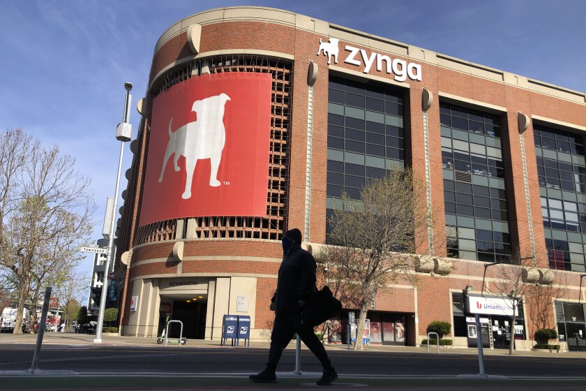 FILE - A pedestrian walks in front of a sign at Zynga in San Francisco, Tuesday, March 16, 2021. 