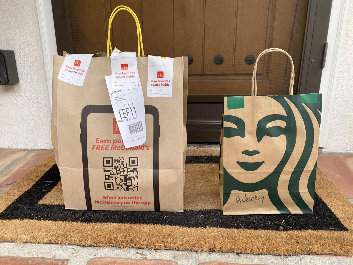 McDonald's ve Starbucks çantaları, Highland Park'ta bir verandada duruyor.