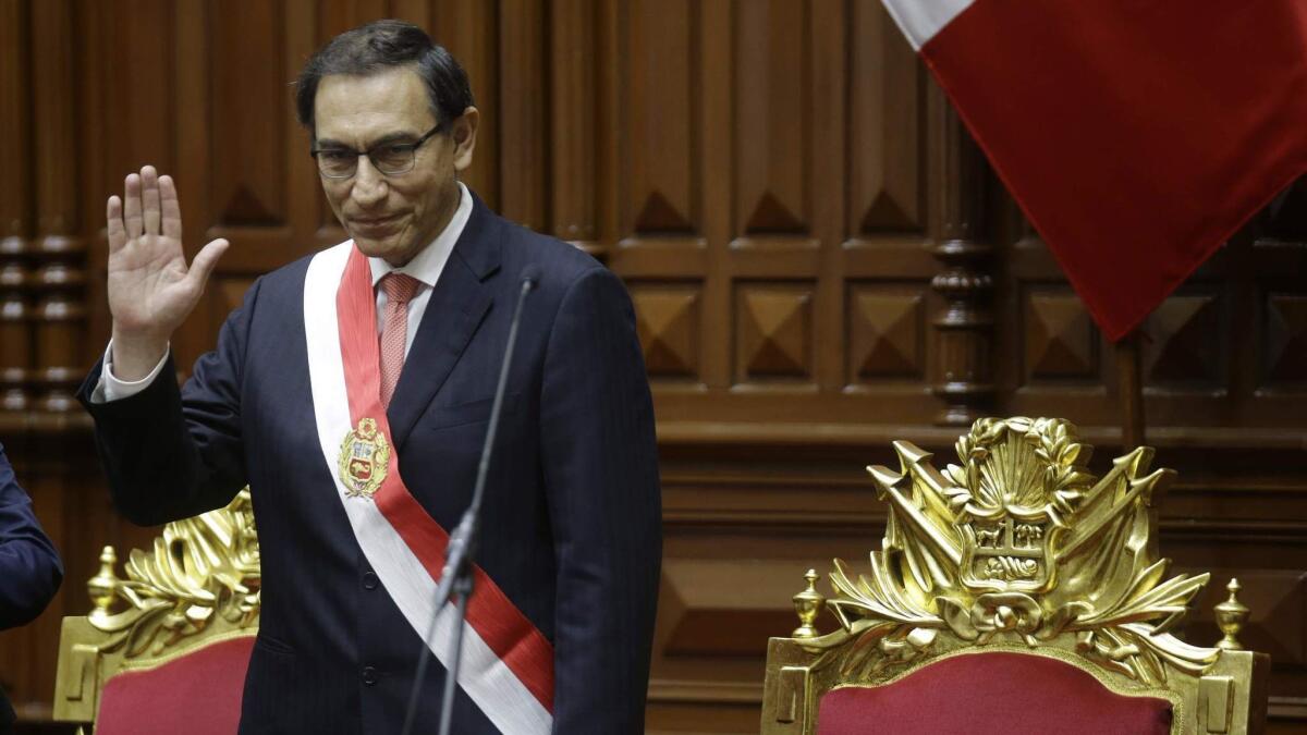 Peruvian President Martin Vizcarra waves after being sworn into office in Lima, Peru, on Friday. His predecessor, Pedro Pablo Kuczynski, resigned over corruption allegations.