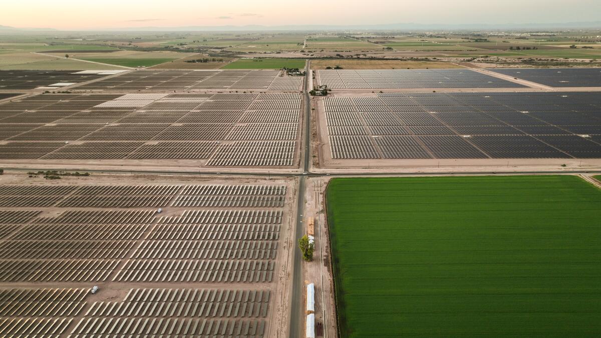 A bird's eye view of solar panels and green farmland