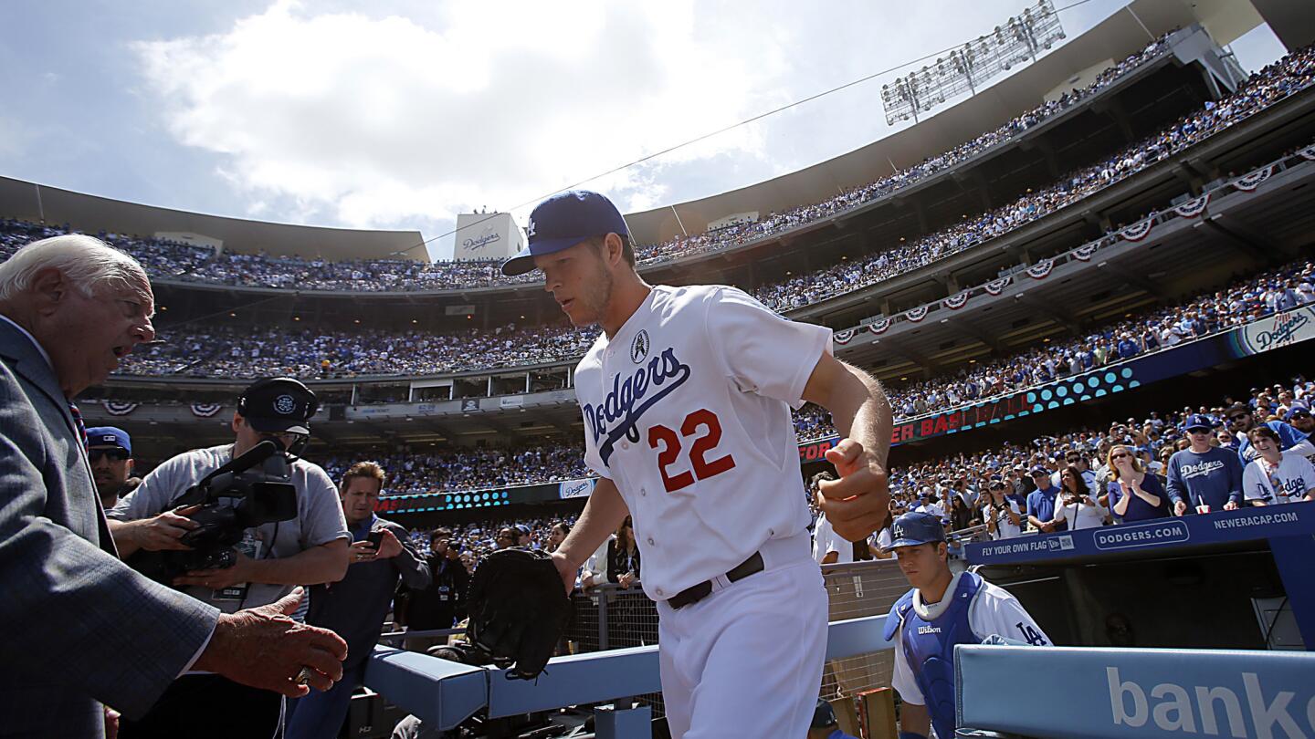 Clayton Kershaw is greeted by former Dodgers manager Tom Lasorda as he takes the field during the team's 2013 season opener. Kershaw, a two-time Cy Young award winner and a four-time All-Star, has established himself as the cornerstone of the Dodgers' pitching staff.