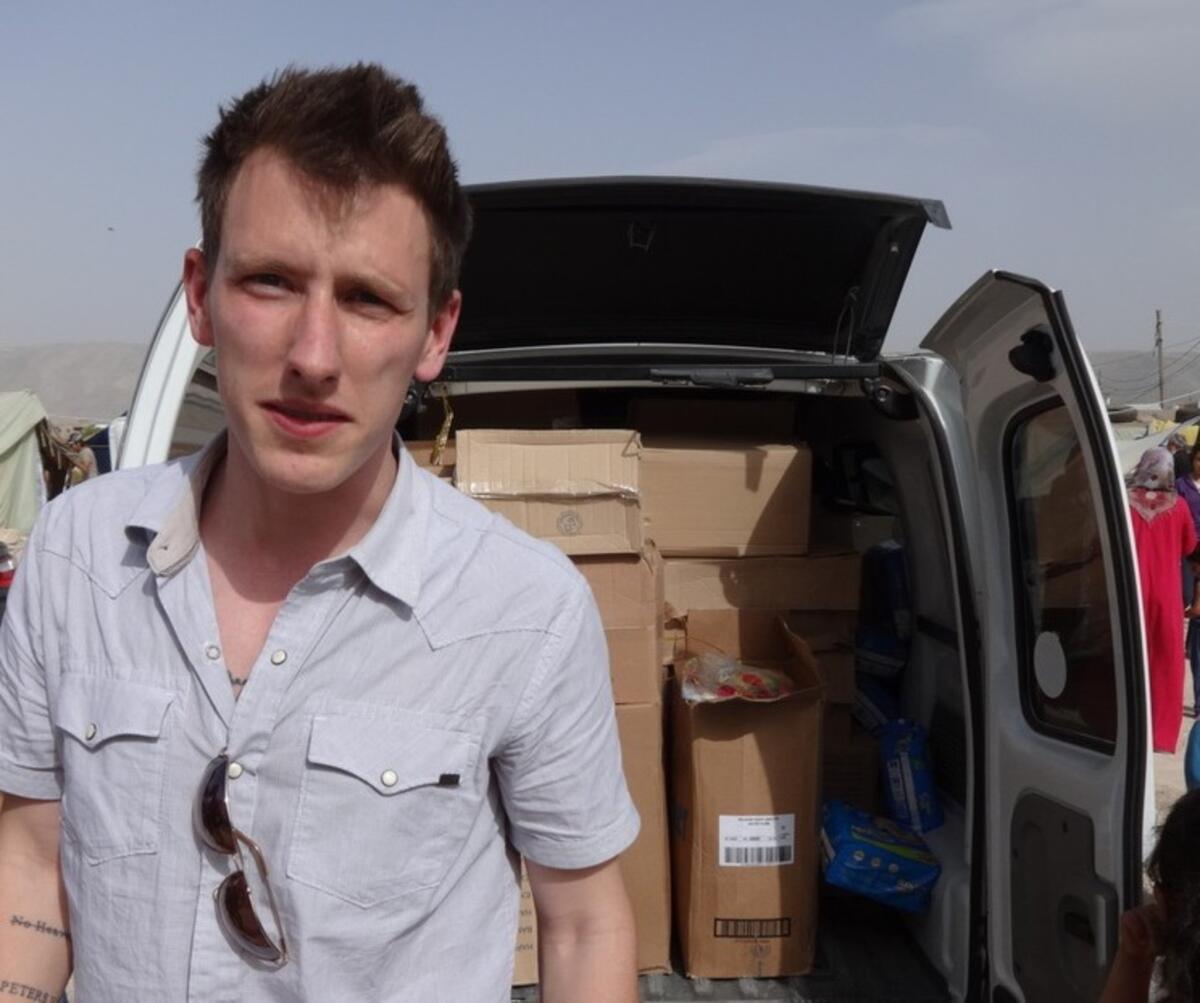 Peter Kassig stands in front of a truck filled with supplies for Syrian refugees in a photo provided by his family. The White House confirmed Sunday that he had been beheaded by Islamic State.