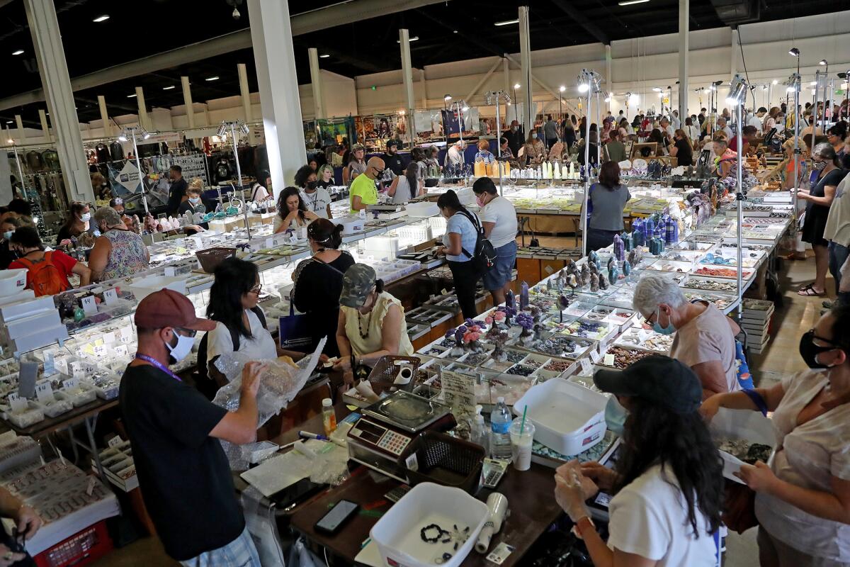 Shoppers hunt for treasure Friday at the Gem Faire in Costa Mesa.