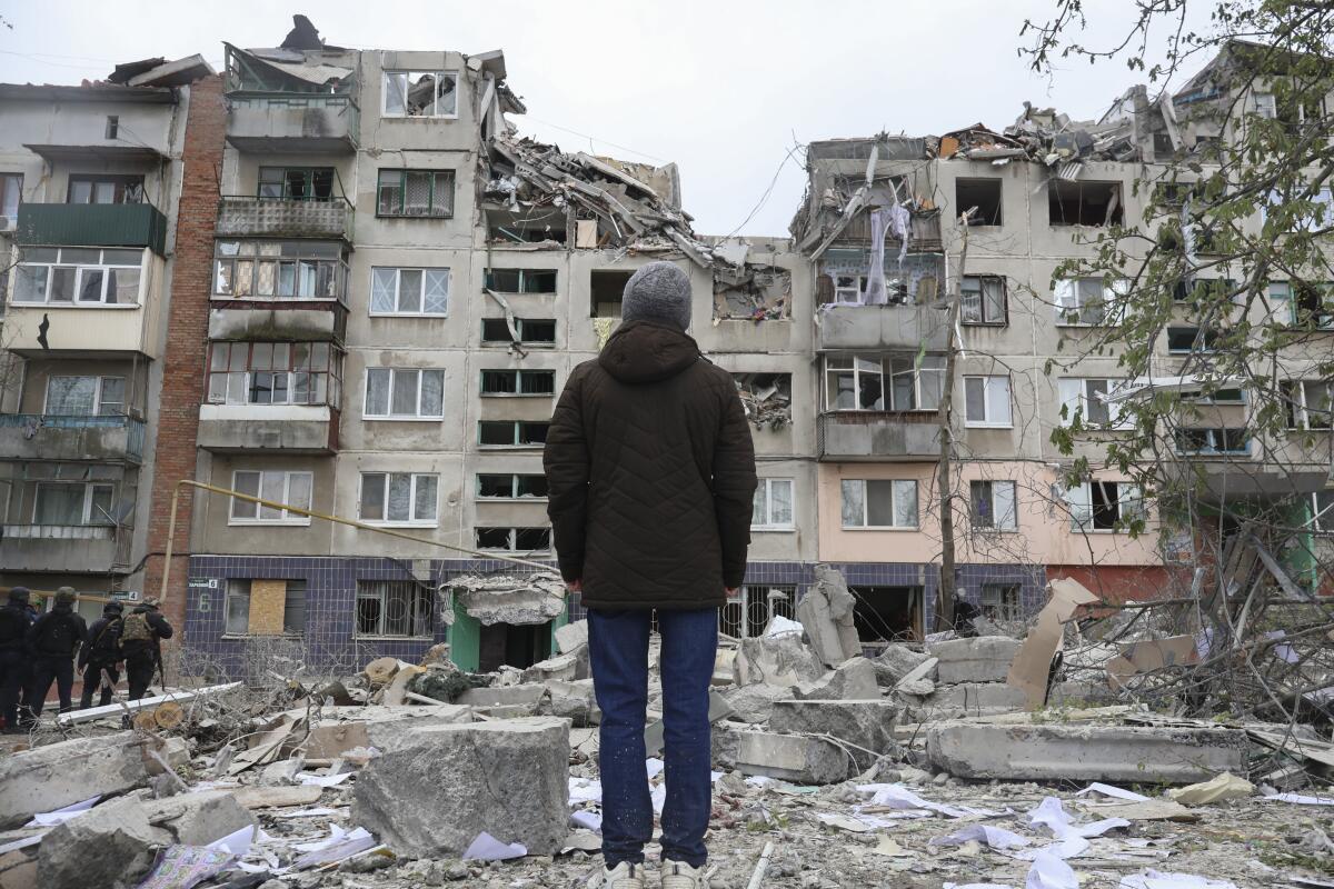 A local resident looks at his home, damaged in a Russian rocket attack.