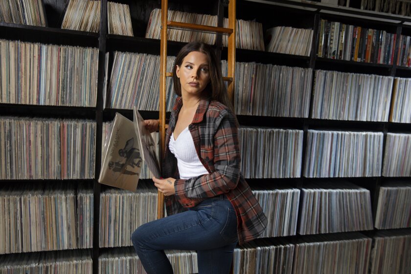 Singer Lana Del Rey in a library of vinyl albums