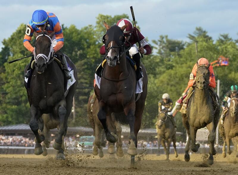 Dornoch, center, crosses the finish line ahead of Mindframe, left to win the Belmont Stakes.
