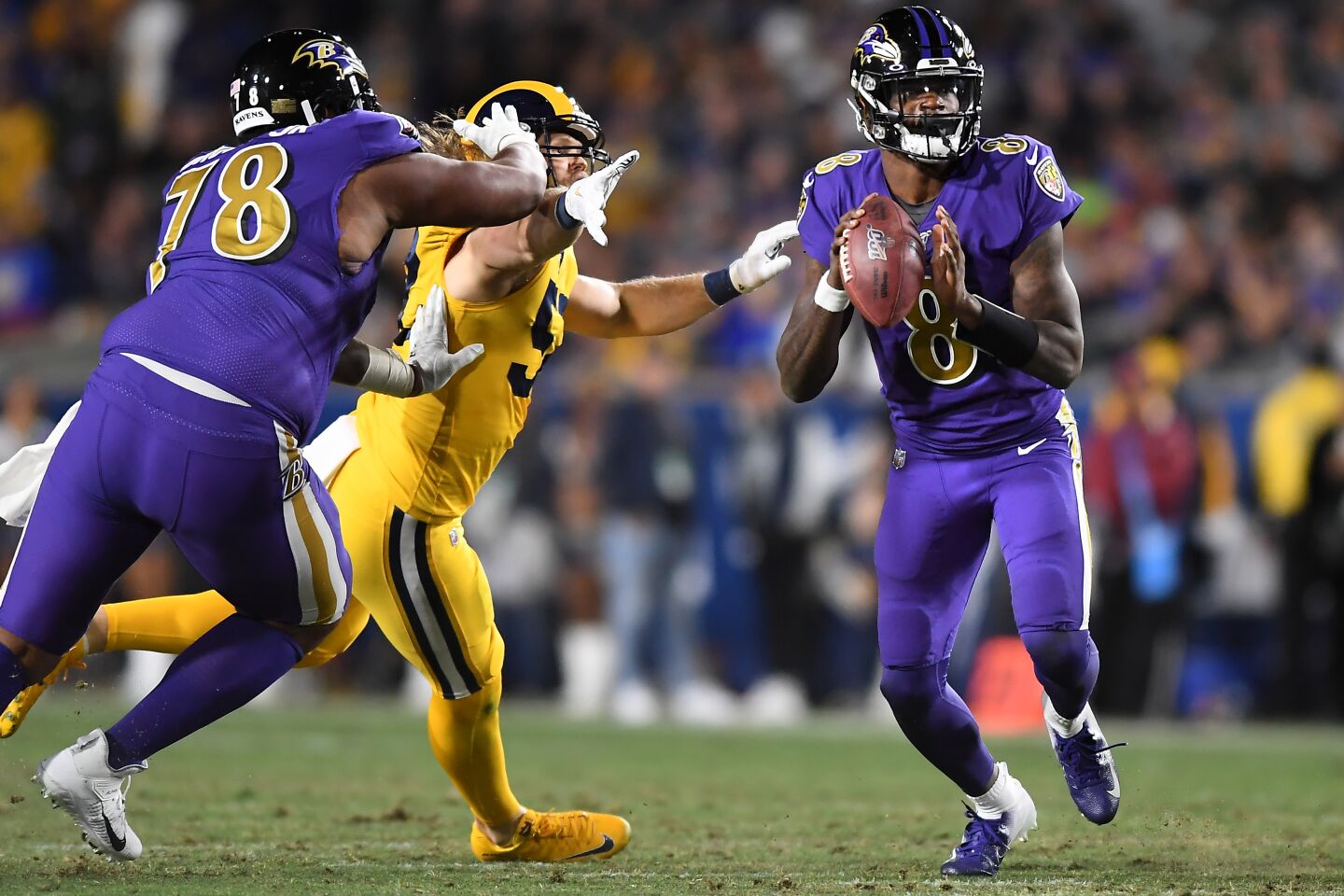 Ravens quarterback Lamar Jackson looks to throw under pressure from Rams linebacker Clay Matthews during the second quarter of a game Nov. 25 at the Coliseum.