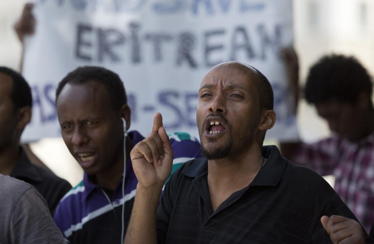 During a protest outside the prime minister's office in Jerusalem, an Eritrean immigrant calls for granting refugee status to African immigrants who made their way into Israel.