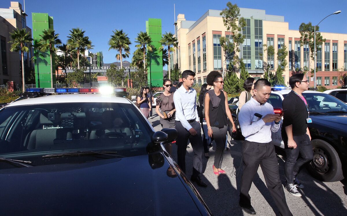 Employees make their way back to work after police cleared KABC following a bomb threat on Wednesday, September 30, 2015. A 22-year-old Glendale man was charged Thursday with making the false bomb threat and another one on Oct. 9, officials said.