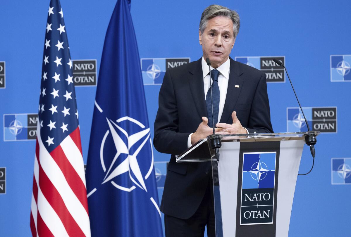 Antony Blinken speaks at a lectern with the NATO logo 