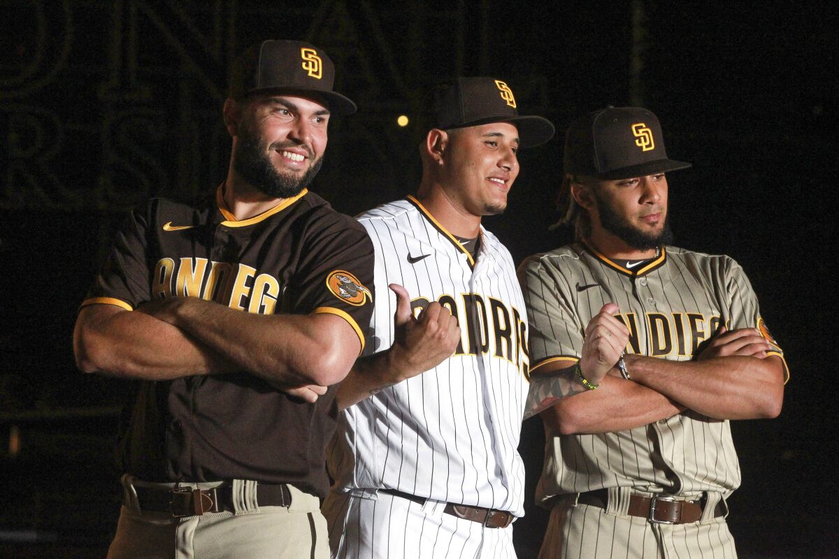 Eric Hosmer, Manny Machado and Fernando Tatis Jr. show off the Padres' new uniforms at Petco Park in November 2019.