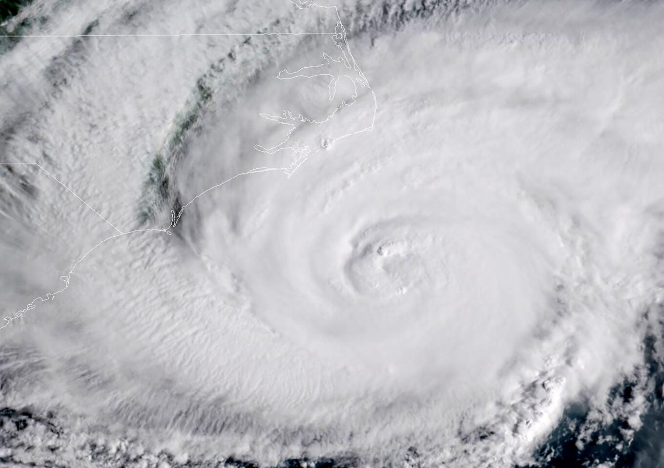 This NOAA/RAMMB satellite image taken at 13:15 UTC on September 13, 2018, shows Hurricane Florence beginning to hit the US east coast. - Florence edged closer to the east coast of the US Thursday, with tropical-force winds and rain already lashing barrier islands just off the North Carolina mainland. The huge storm weakened to a Category 2 hurricane overnight, but forecasters warned that it still packed a dangerous punch, 110 mile-an-hour (175 kph) winds and torrential rains. (Photo by Jose ROMERO / NOAA/RAMMB / AFP) / RESTRICTED TO EDITORIAL USE - MANDATORY CREDIT "AFP PHOTO / NOAA/RAMMB" - NO MARKETING NO ADVERTISING CAMPAIGNS - DISTRIBUTED AS A SERVICE TO CLIENTSJOSE