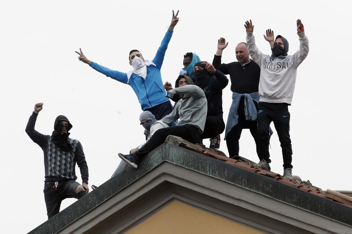 Inmates stage a protest against new rules to cope with coronavirus emergency, atop the roof of the San Vittore prison in Milan on Monday. Italy took a page from China's playbook Sunday, attempting to lock down 16 million people — more than a quarter of its population — for nearly a month to halt the relentless march of the new coronavirus across Europe.