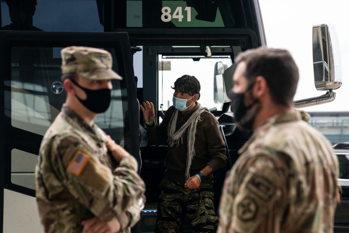 Evacuees who fled Afghanistan board buses on Tuesday, Aug. 31, 2021.