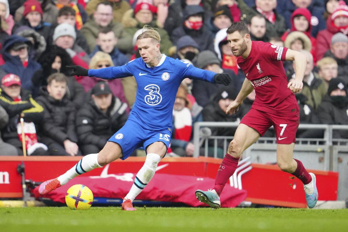 Mykhailo Mudryk del Chelsea controla el balón mientras lo intenta defender James Milner del Liverpool