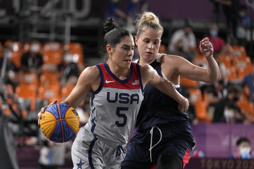 Kelsey Plum drives the basketball past Olga Frolkina of the Russian Olympic Committee at the Tokyo Olympics