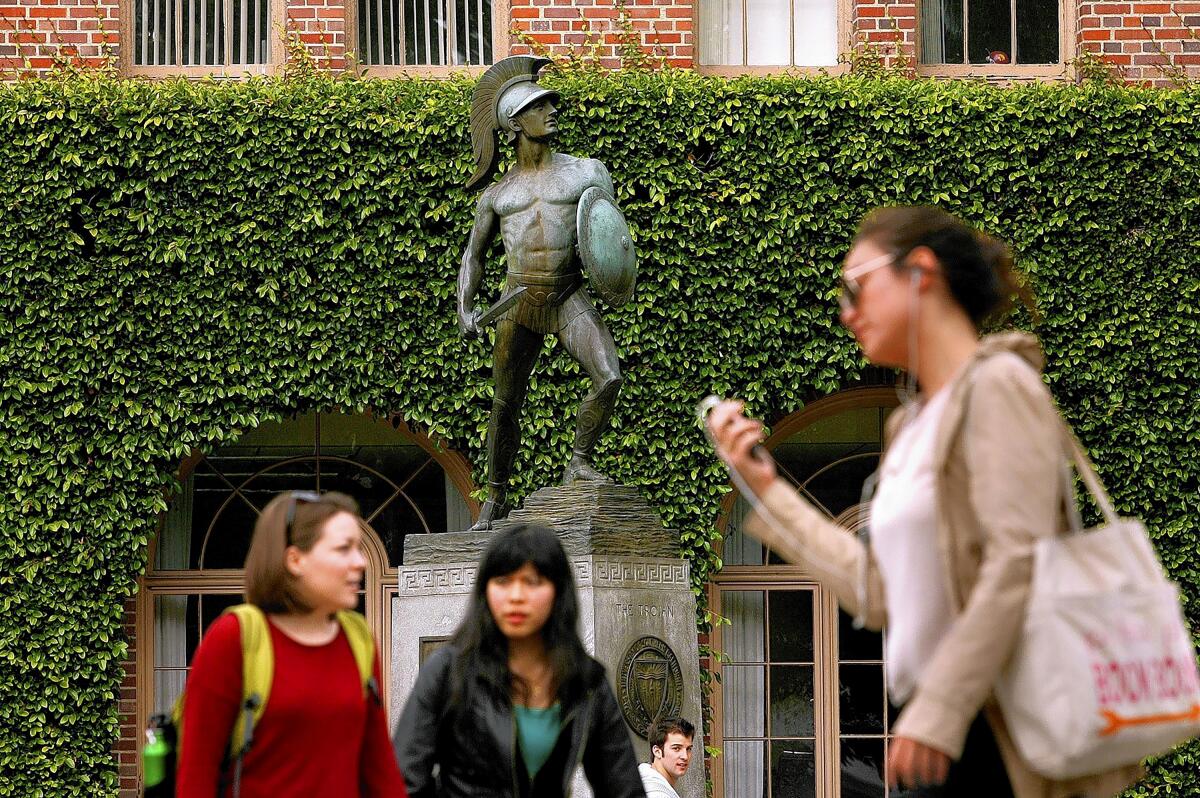Students pass by the Tommy Trojan statue on the USC campus.