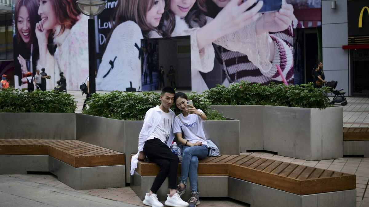 A couple takes a selfie in Beijing. One of the biggest constraints on Chinese growth is a shrinking workforce. The number of Chinese ages 15 to 60 began to fall in 2012, and decreased by an estimated 5.48 million in 2017.