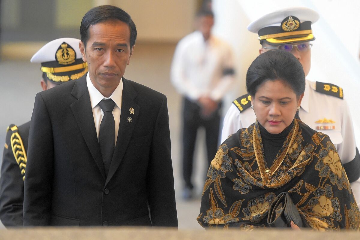 President Joko Widodo, seen here with his wife, Iriana Joko Widodo, has gotten some praise along with the criticism, and an analyst noted that his election may have generated unrealistic expectations.