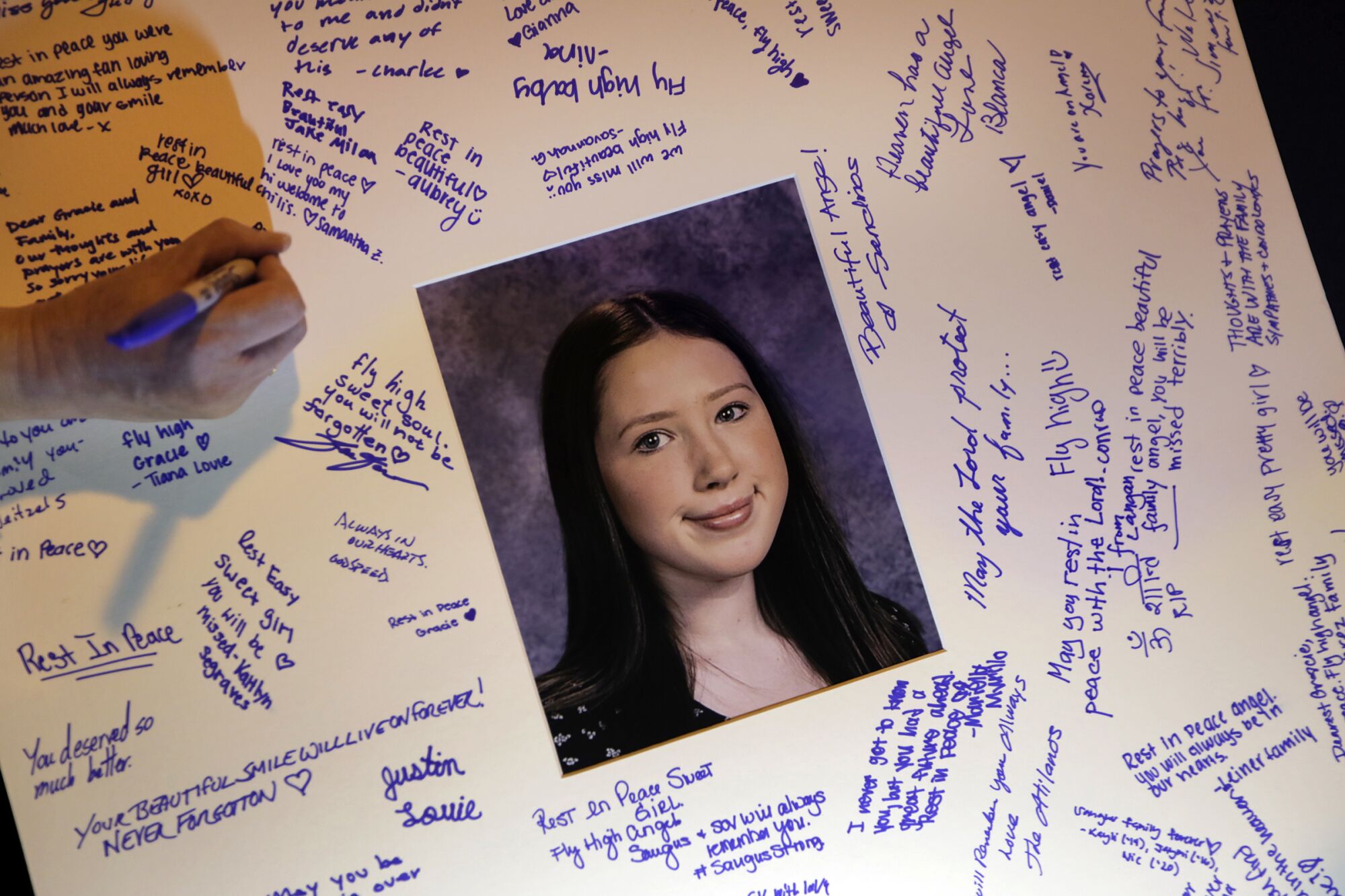 Students sign a card in memory of 15-year-old Gracie Anne Muehlberger, who was killed in the shooting at Saugus.