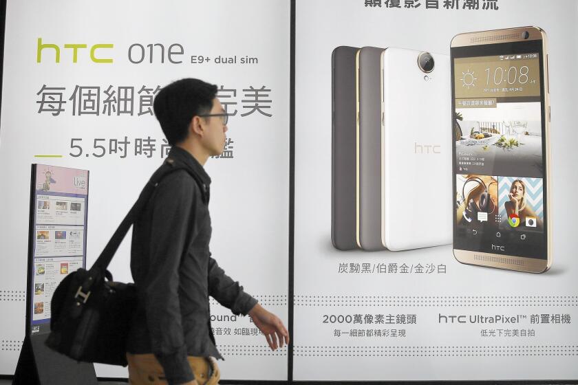 HTC's One series high-end smartphones sold well initially in 2013, but consumer interest dropped off after a lack of new must-have features. Above, a man walks past an HTC ad in Taipei, Taiwan.