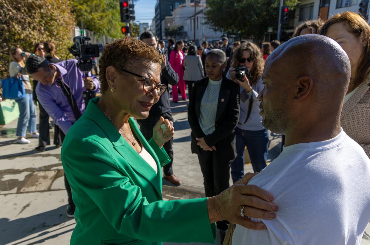 LOS ANGELES, CA - DECEMBER 06: Mayor Karen Bass, left, speaks Darnell Woods, a houseless person, after a press conference held on a city block cleaned from houseless persons on 6600 block of Selma Avenue on Wednesday, Dec. 6, 2023 in Los Angeles, CA. (Irfan Khan / Los Angeles Times)
