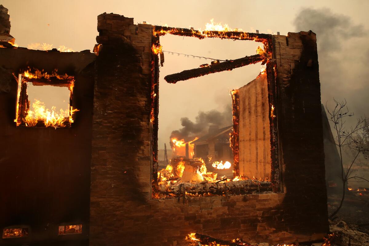 A structure continues to burn after the Kincade fire moved through the area Thursday in Geyserville, Calif.