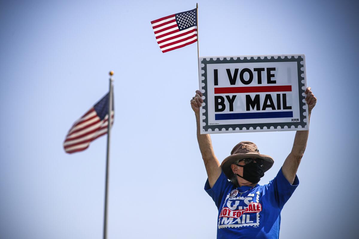 Jimmy McGraw takes part in a rally supporting the Postal Service in front of a Santa Ana post office.