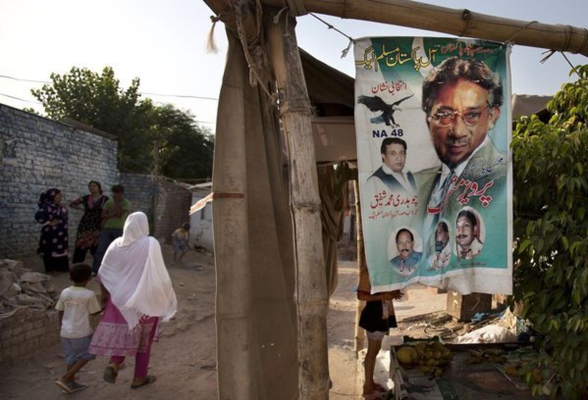 A woman walks past an election banner for Pakistan's former military ruler, Pervez Musharraf, in a neighborhood of Islamabad.