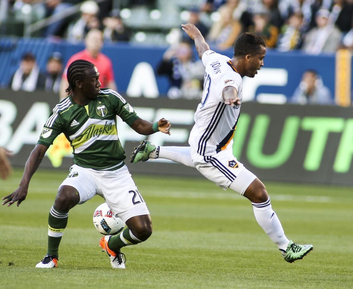 Portland Timbers midfielder Diego Chara, left, and Los Angeles Galaxy forward Giovani dos Santos battle for ball during the first half of an MLS soccer game in Carson, Calif., Sunday April 10, 2016. (AP Photo/Ringo H.W. Chiu)