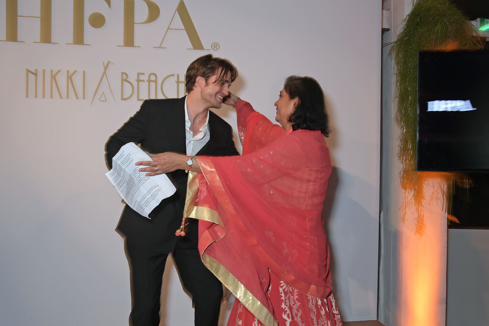  Robert Pattinson and former HFPA President Meher Tatna move in to hug each other