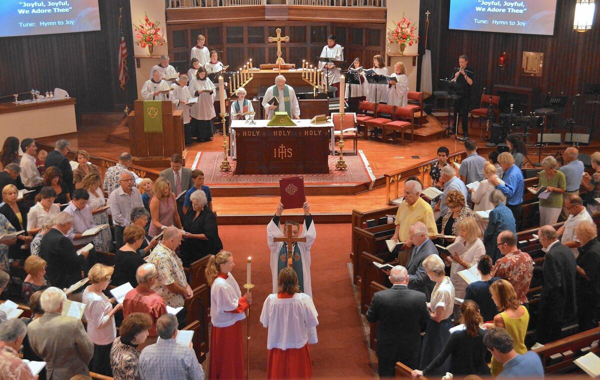 The Rev. Richard Crocker conducts a service at St. James church in 2013. The Newport church is being sold to a developer.