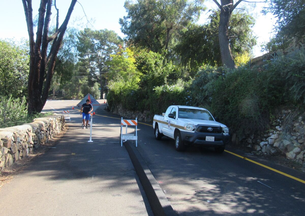 A runner makes his way up Mount Helix Drive, protected inside the newly built berm separating cars from pedestrians.