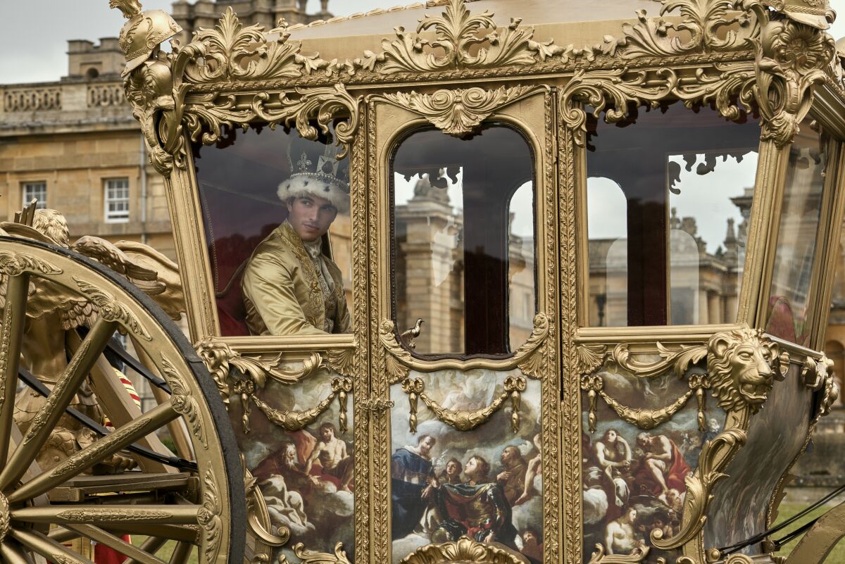 King George looks out of the window of a gilded carriage.