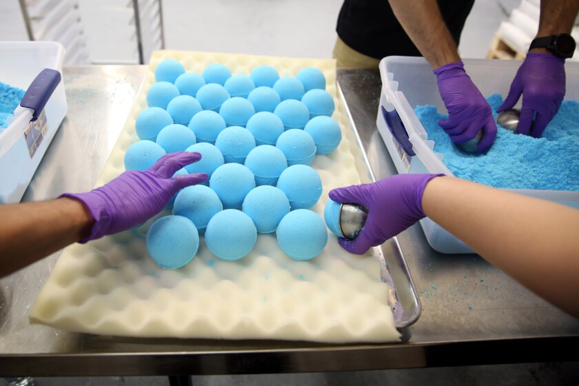 Workers at the Kush Queen headquarters assemble Relax CBD bath bombs, the company’s signature product. 