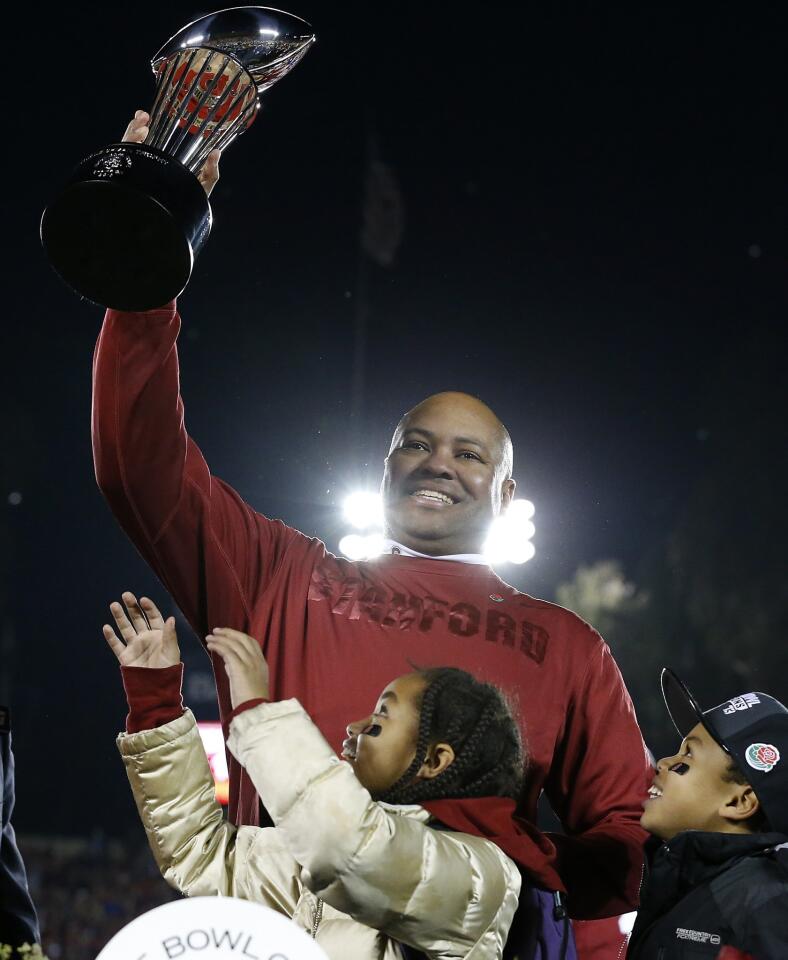 Stanford Coach David Shaw raises the Rose Bowl trophy next to his children after a 20-14 victory over Wisconsin in the Rose Bowl on Tuesday night in Pasadena.