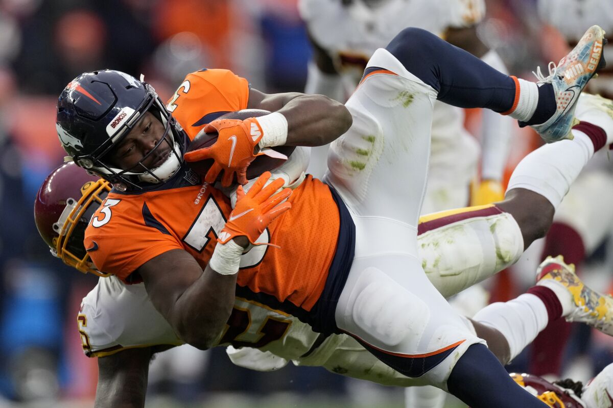 Denver Broncos running back Javonte Williams (33) is hit by Washington Football Team safety Landon Collins during the second half of an NFL football game, Sunday, Oct. 31, 2021, in Denver. (AP Photo/David Zalubowski)