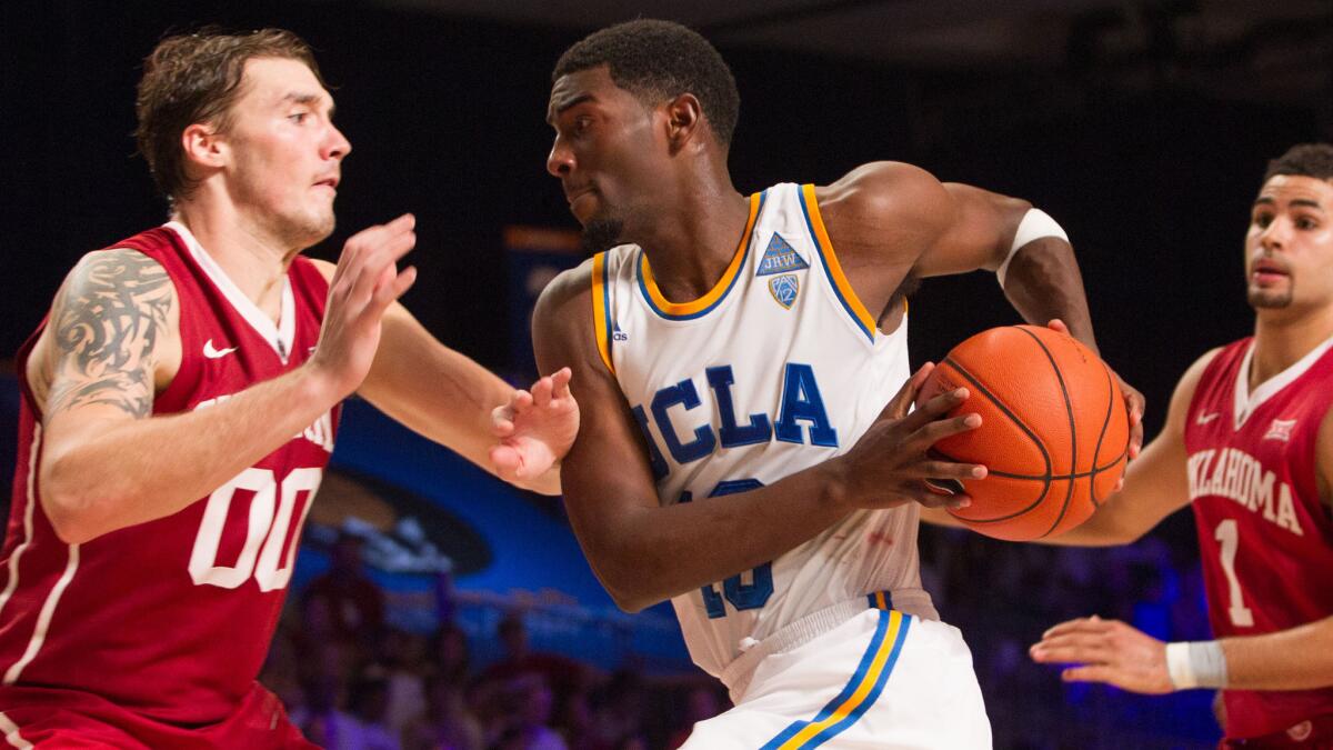 UCLA guard Isaac Hamilton, right, drives to the basket in front of Oklahoma's Ryan Spangler during the Bruins' 75-65 loss on Nov. 26.