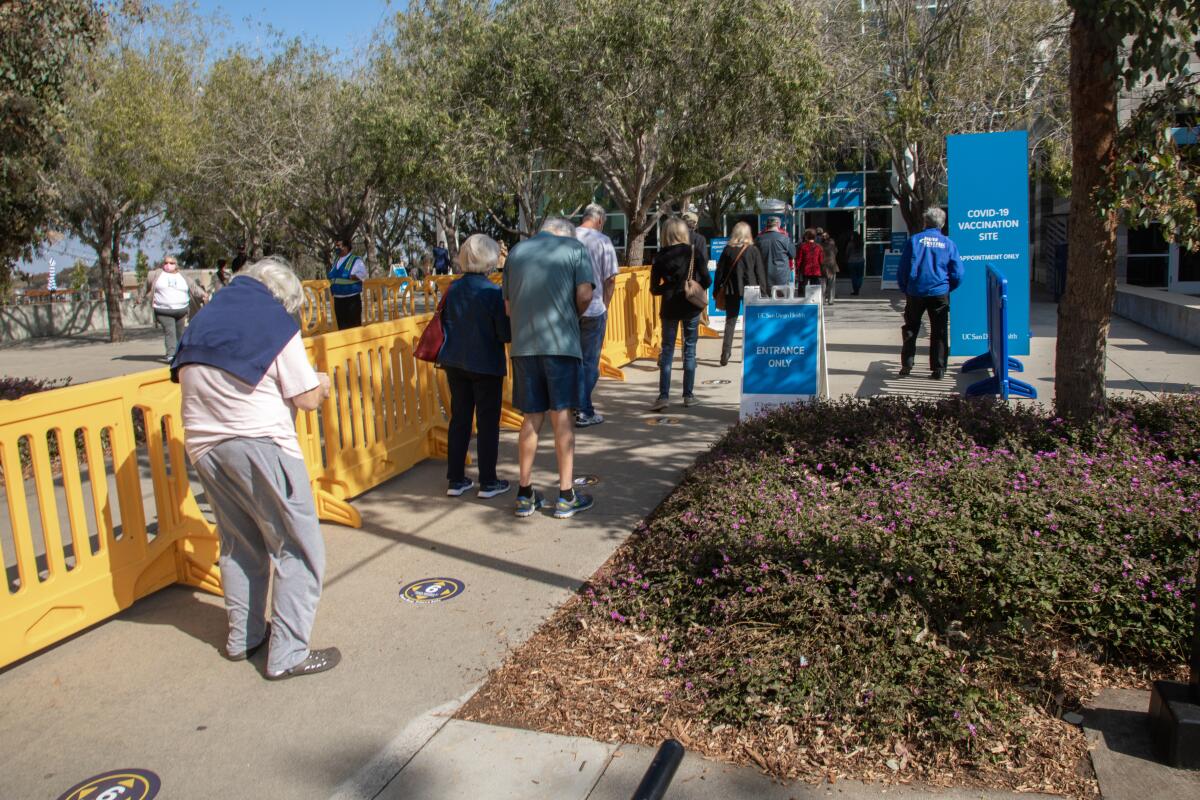 People wait to get into the COVID-19 vaccine superstation at RIMAC Arena at UC San Diego.