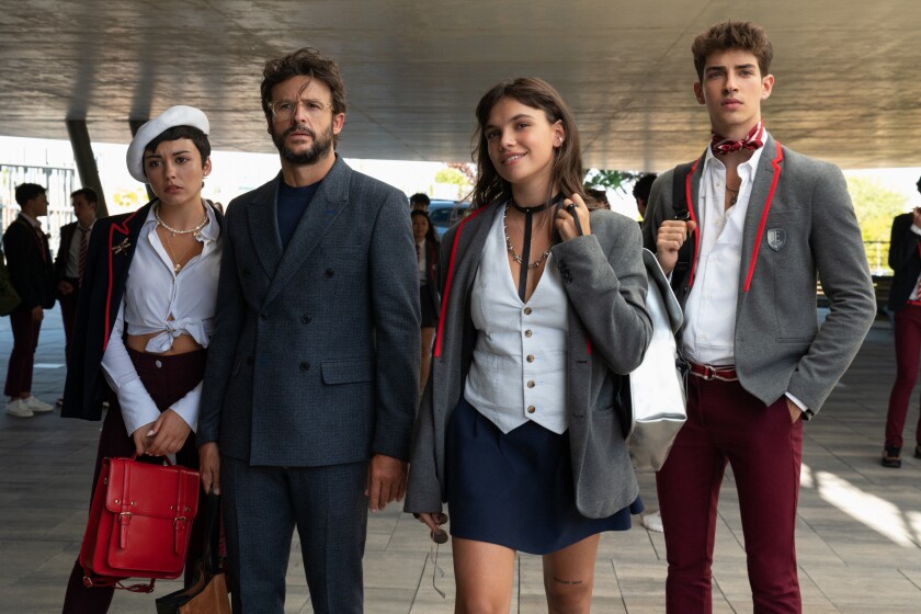 A man and his three children dressed in private school uniforms