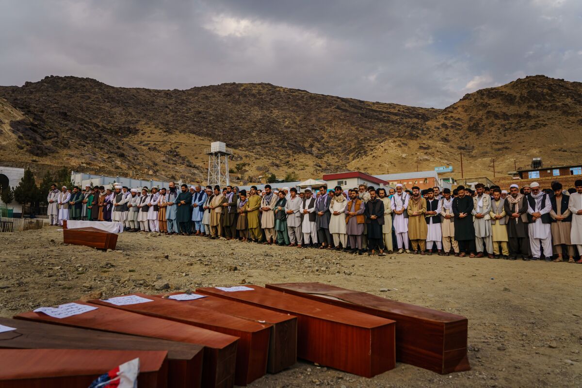Mourners at a mass funeral in Kabul on Aug. 30 recite prayers for 10 people killed in a U.S. drone strike.