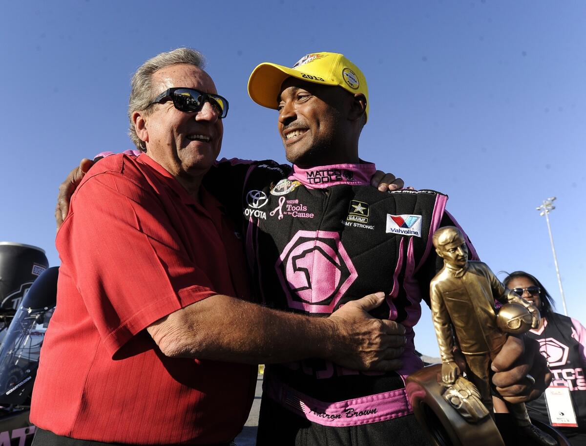 NHRA top fuel dragster driver Antron Brown, right, is congratulated by team owner Don Schumacher after winning an NHRA event in Las Vegas on Oct. 27. Brown has let his scary crash at the Winternationals hasn't slowed him down at Pomona this week.