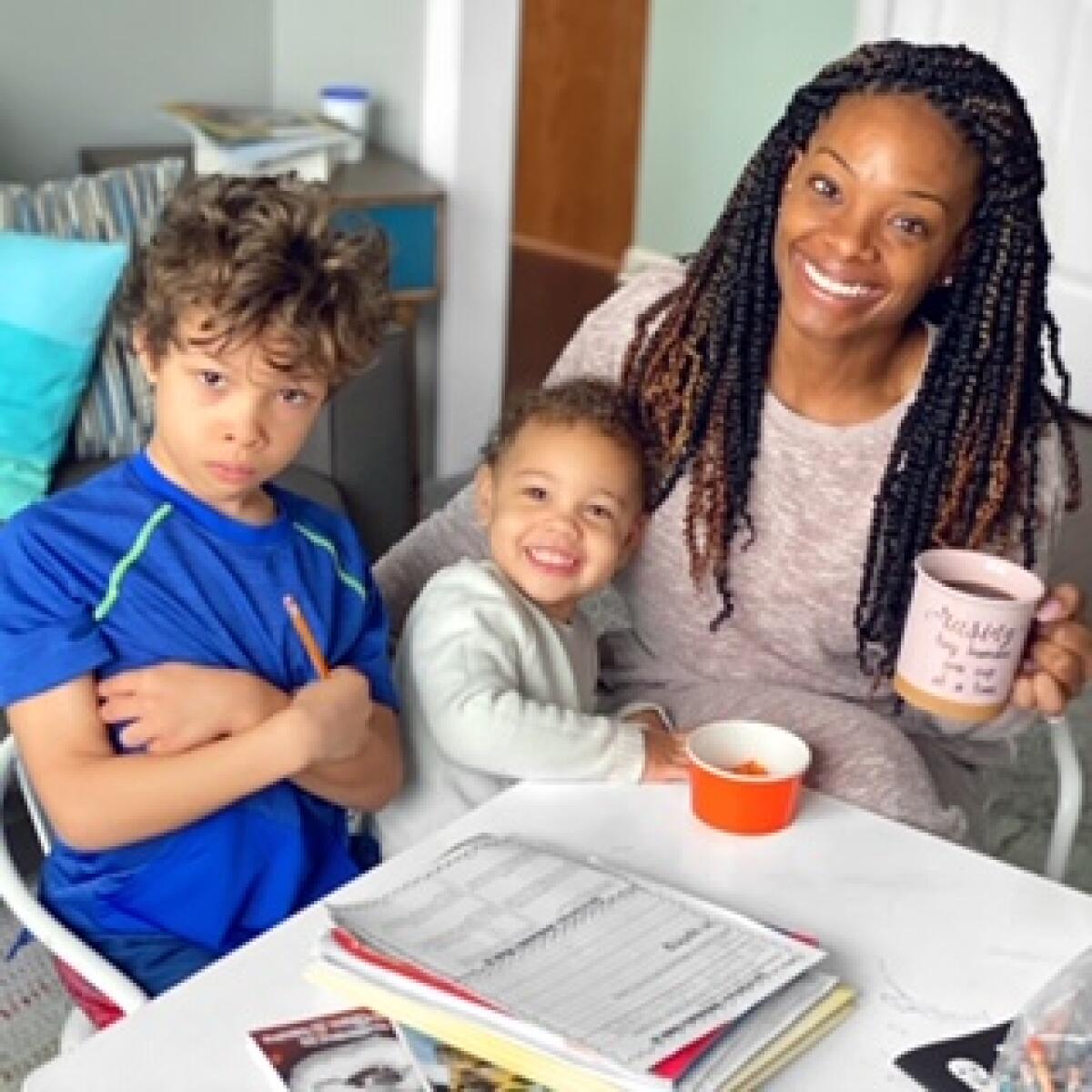 Gabrielle Flowers Rader, a lifestyle influencer and fitness coach from Indiana, helps her children with their schoolwork from home.