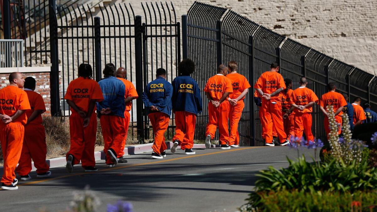 Inmates walk in file in front at San Quentin State Prison in August 2016.