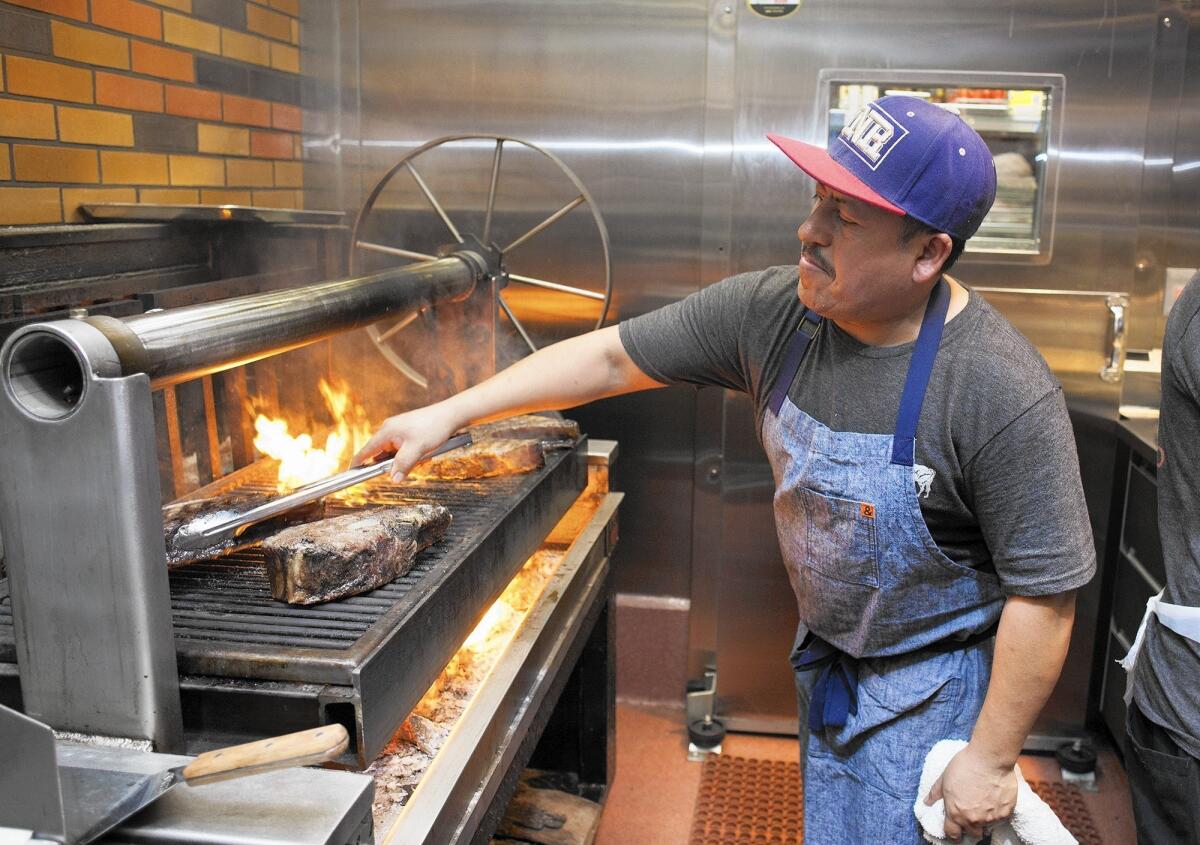 Fernando Rodriguez cooks 3-pound ribeye steaks during a special opening for Chef Amar Santana's new restaurant, Vaca.
