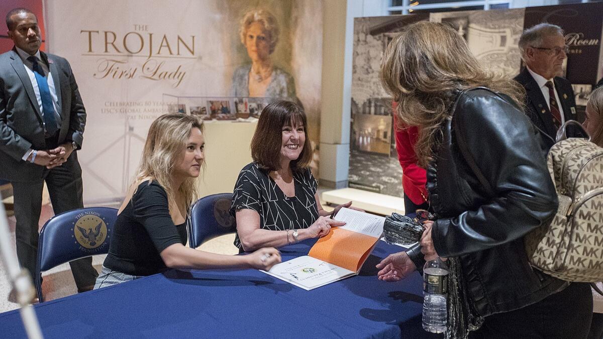 Second Lady Karen Pence, center, and her daughter Charlotte Pence sign copies of their children's book at the Nixon Library on March 22.