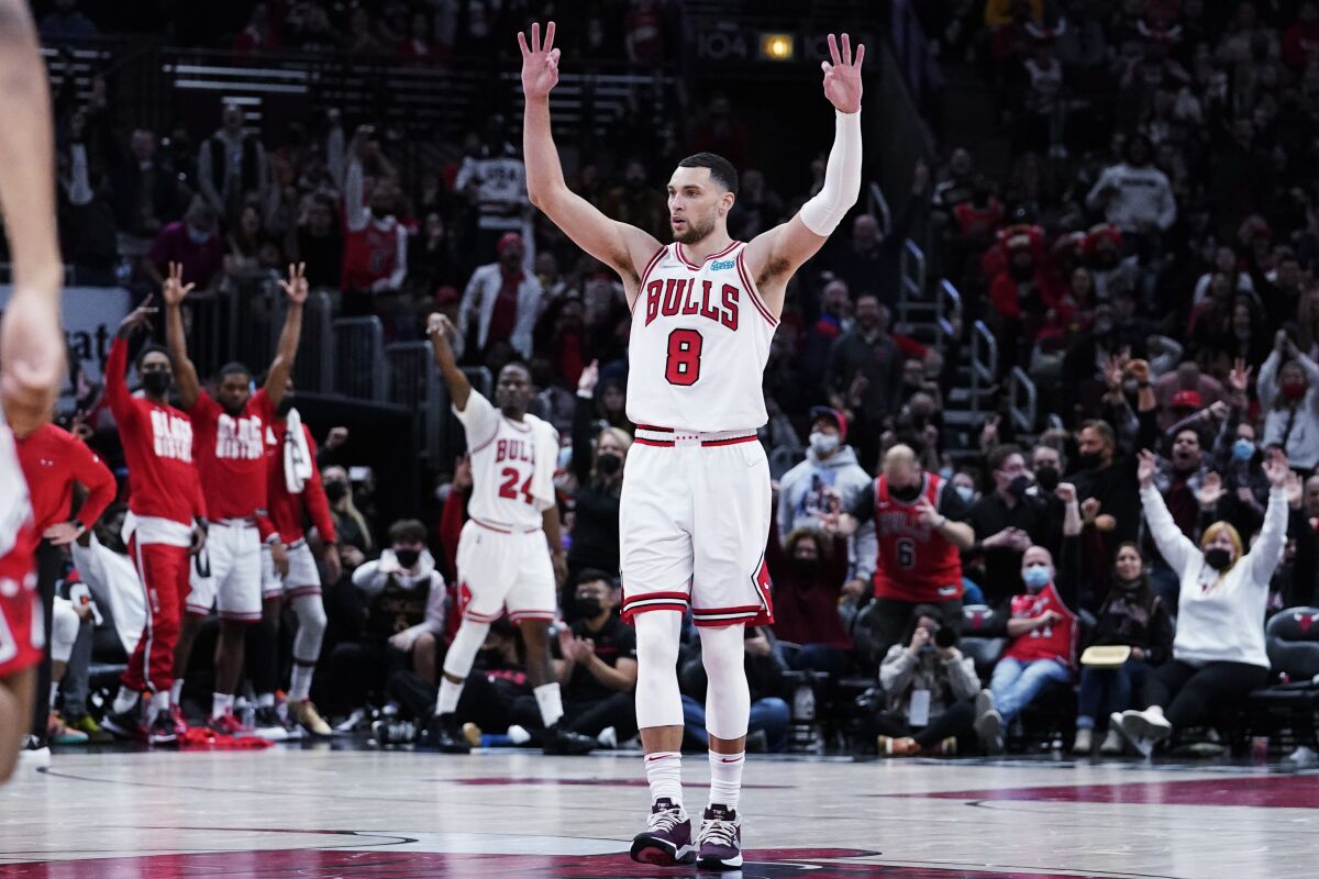Chicago Bulls guard Zach LaVine celebrates after guard Coby White scored a 3-point basket during the second half of an NBA basketball game against the Minnesota Timberwolves in Chicago, Friday, Feb. 11, 2022. (AP Photo/Nam Y. Huh)