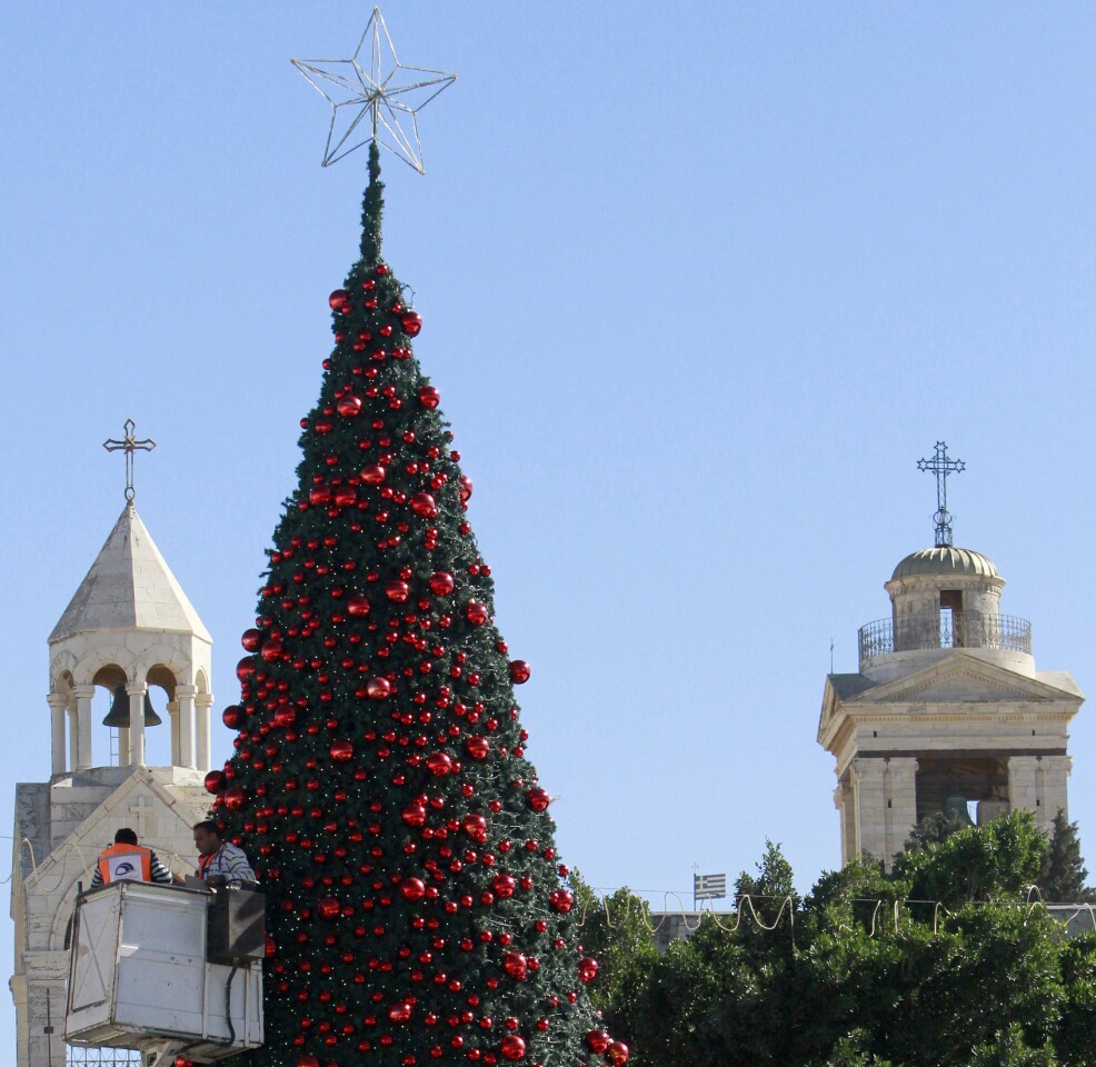 Workers tend to the Christmas tree in Bethlehem's Manger Square, outside the Church of the Nativity, believed to be the birthplace of Jesus Christ.